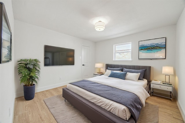 bedroom with light wood finished floors and baseboards