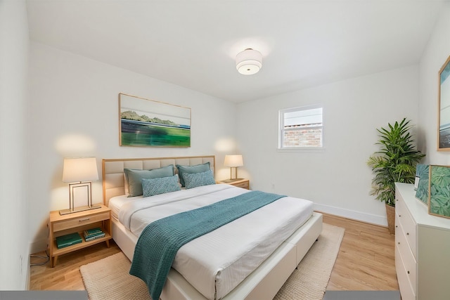 bedroom with light wood finished floors and baseboards