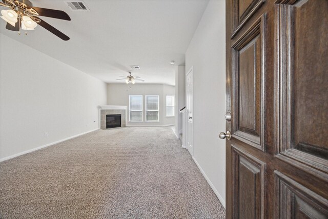 unfurnished living room featuring baseboards, a fireplace, visible vents, and light colored carpet