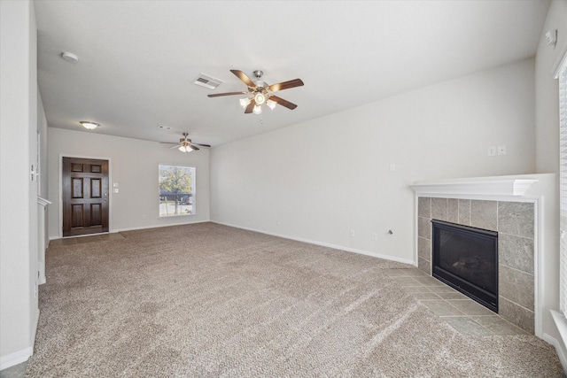 unfurnished living room with a tile fireplace, baseboards, visible vents, and carpet flooring