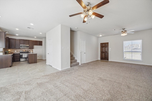 unfurnished living room featuring light carpet, stairway, baseboards, and visible vents