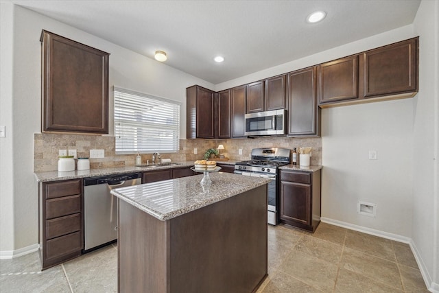 kitchen featuring dark brown cabinetry, tasteful backsplash, stainless steel appliances, and a sink