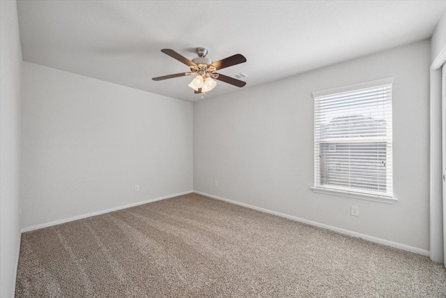 empty room featuring a ceiling fan, carpet flooring, visible vents, and baseboards