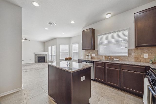 kitchen featuring a sink, visible vents, stainless steel dishwasher, a center island, and gas range oven