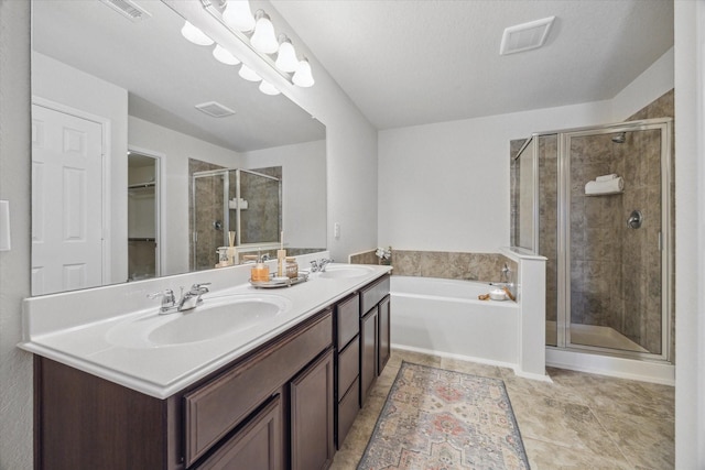 bathroom featuring a stall shower, visible vents, a sink, and a garden tub