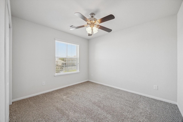 spare room with a ceiling fan, carpet flooring, and baseboards