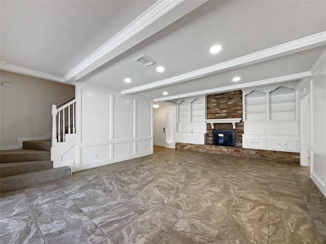 basement with visible vents, a decorative wall, crown molding, a fireplace, and stairs