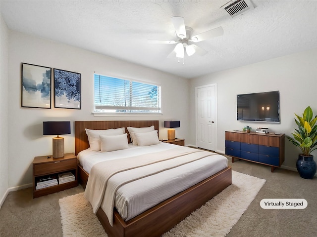 bedroom with visible vents, light colored carpet, a textured ceiling, and baseboards