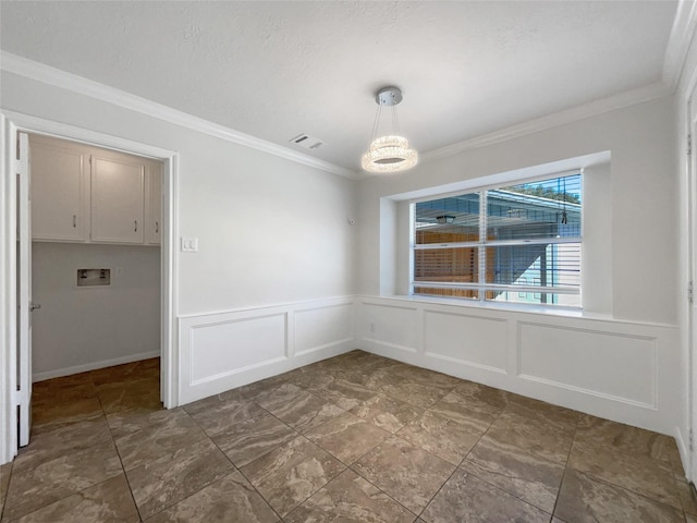 unfurnished dining area with visible vents, a decorative wall, crown molding, a wainscoted wall, and a notable chandelier