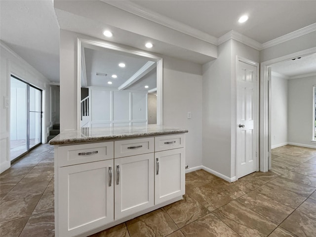 kitchen featuring ornamental molding, light stone counters, white cabinetry, recessed lighting, and baseboards