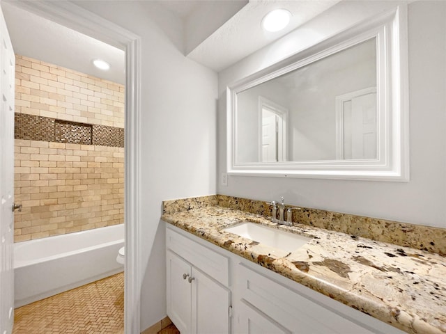 bathroom featuring recessed lighting, toilet, vanity, and washtub / shower combination