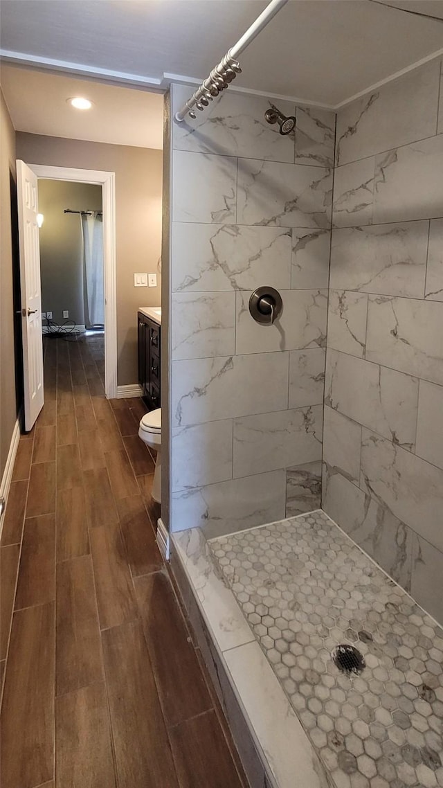 bathroom with wood finish floors, a shower stall, and vanity