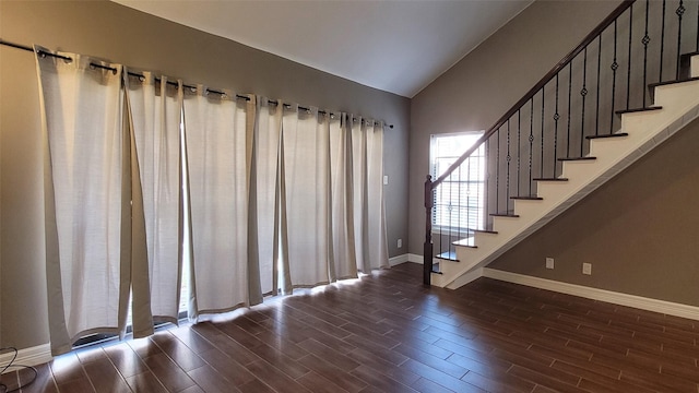 interior space featuring lofted ceiling, wood finish floors, stairs, and baseboards