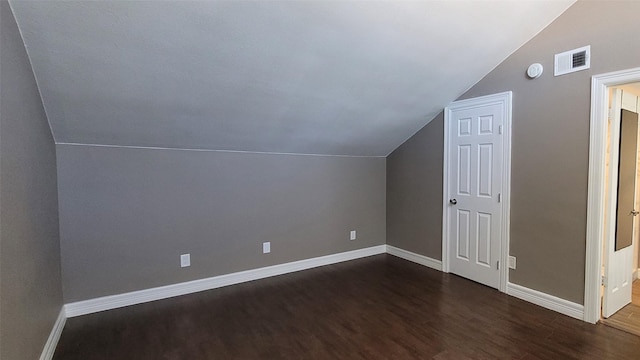 bonus room with vaulted ceiling, visible vents, dark wood finished floors, and baseboards