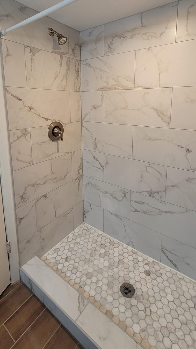 bathroom featuring tiled shower and wood finished floors