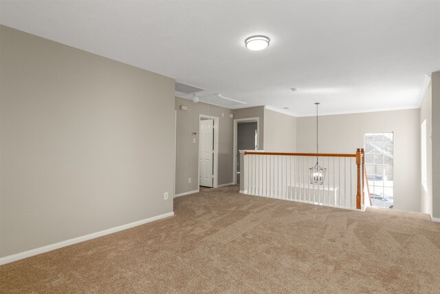 empty room with carpet floors, crown molding, visible vents, attic access, and baseboards