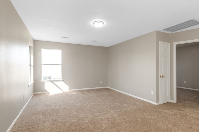 carpeted empty room featuring visible vents and baseboards