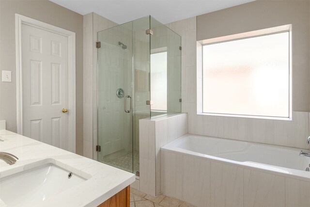 full bath featuring double vanity, a garden tub, a sink, and a stall shower