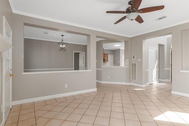 empty room with light tile patterned floors, baseboards, visible vents, and crown molding