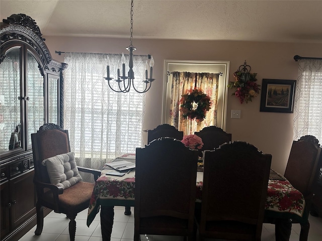 dining room with tile patterned floors, a textured ceiling, and an inviting chandelier