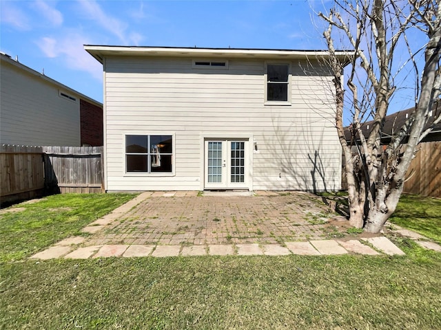 rear view of house with french doors, a patio, a lawn, and a fenced backyard