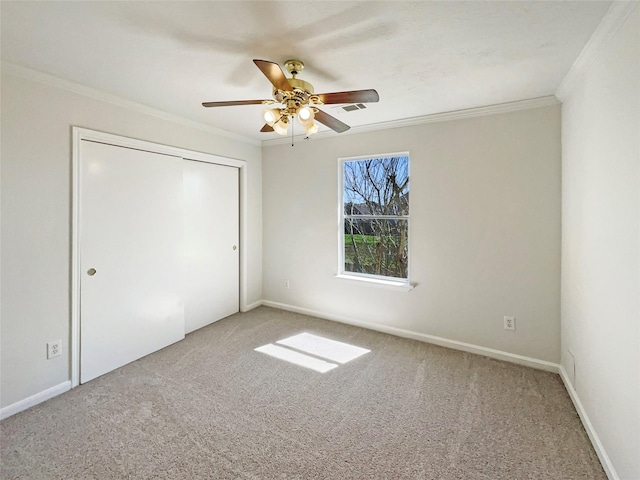 unfurnished bedroom featuring a closet, carpet floors, baseboards, and ornamental molding