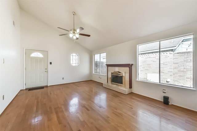 unfurnished living room featuring a fireplace, high vaulted ceiling, a ceiling fan, and wood finished floors