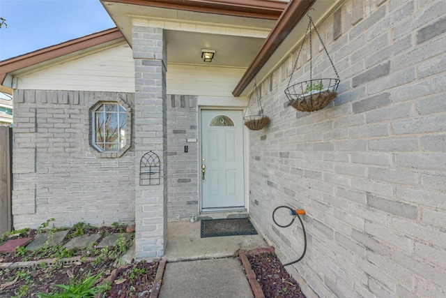 doorway to property with brick siding