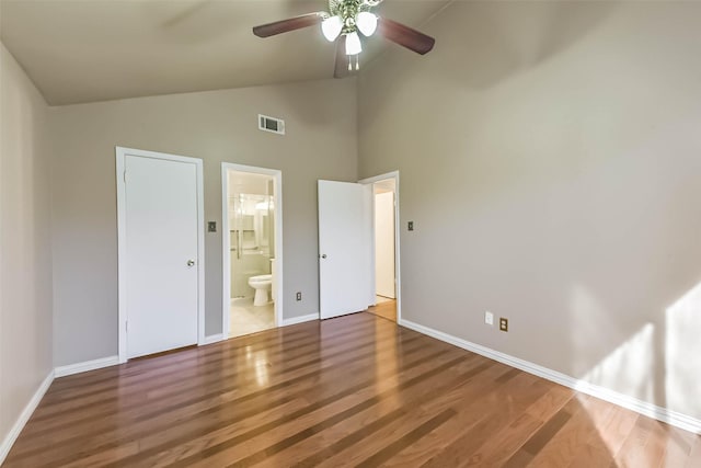 unfurnished bedroom with visible vents, ceiling fan, baseboards, wood finished floors, and ensuite bath