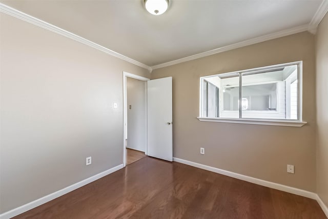 spare room featuring wood finished floors, baseboards, and ornamental molding