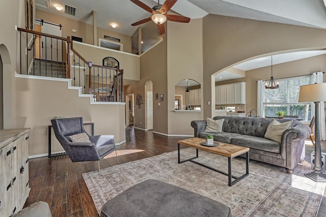 living area featuring stairway, dark wood-style floors, visible vents, baseboards, and arched walkways