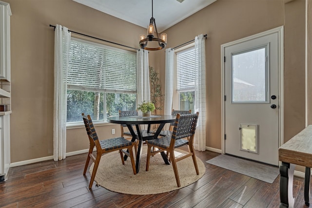 dining space featuring dark wood-style floors, plenty of natural light, and an inviting chandelier