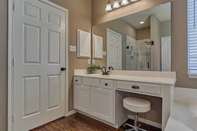 full bath with vanity, wood finished floors, a stall shower, and baseboards