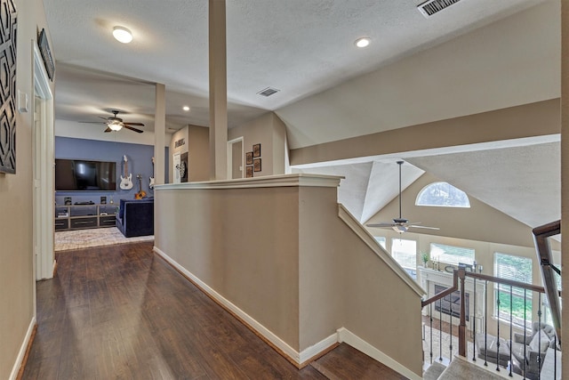 corridor with an upstairs landing, dark wood-style floors, and lofted ceiling