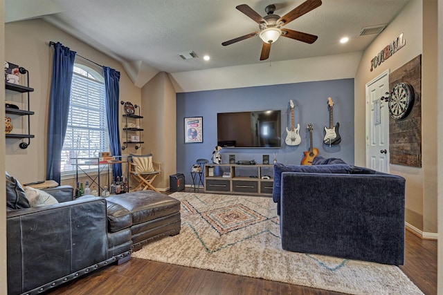 living room with visible vents, lofted ceiling, baseboards, and wood finished floors