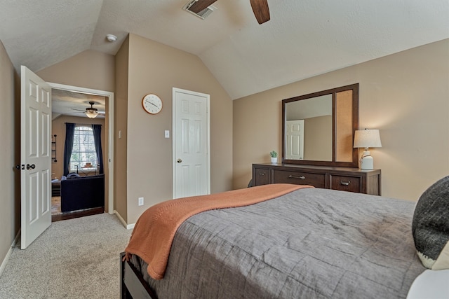 bedroom featuring visible vents, baseboards, ceiling fan, vaulted ceiling, and light carpet