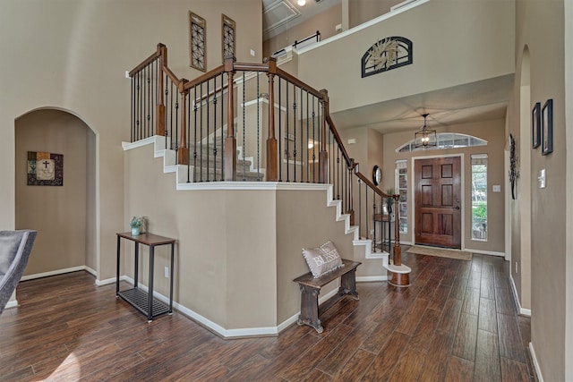 foyer entrance with a high ceiling, wood finished floors, and baseboards