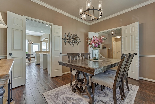 dining room with dark wood finished floors, ornamental molding, baseboards, and a chandelier