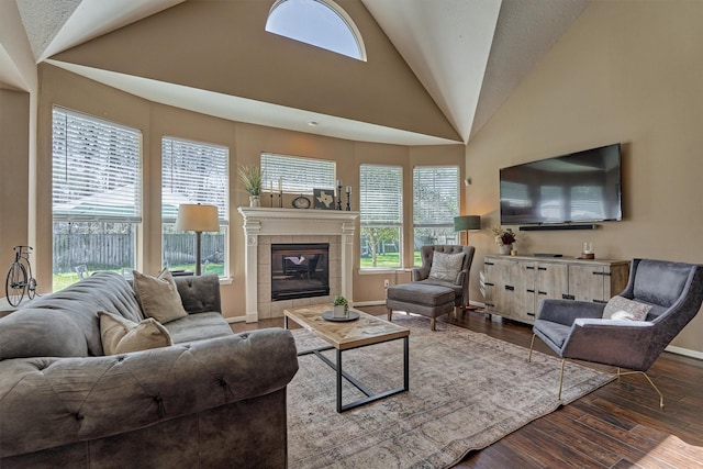 living area with baseboards, wood finished floors, and a tiled fireplace