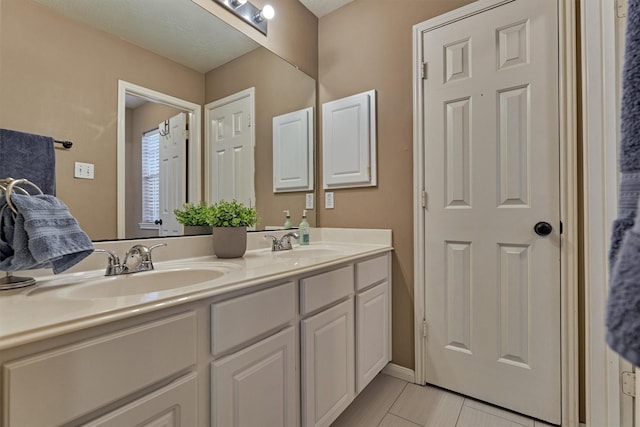 full bathroom with double vanity, tile patterned flooring, and a sink