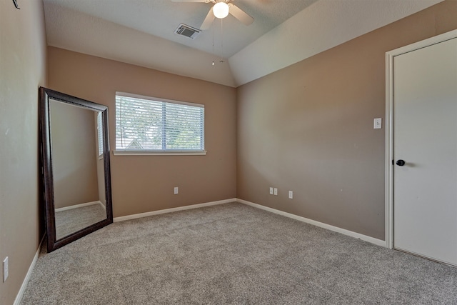 unfurnished bedroom with visible vents, carpet floors, baseboards, ceiling fan, and vaulted ceiling