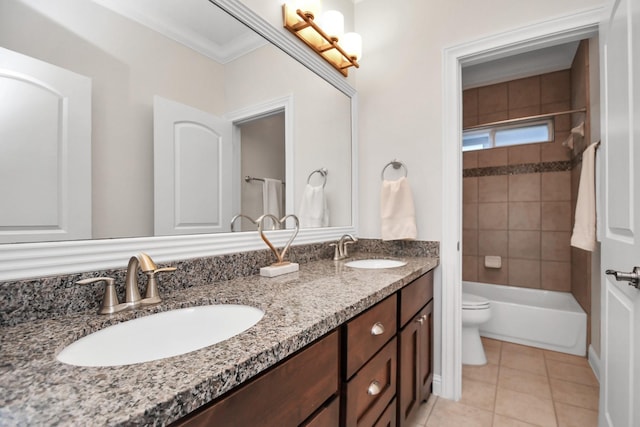 bathroom with double vanity, a sink, toilet, and tile patterned floors