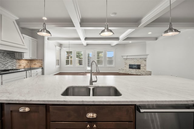 kitchen with a sink, gas stovetop, open floor plan, dishwasher, and tasteful backsplash