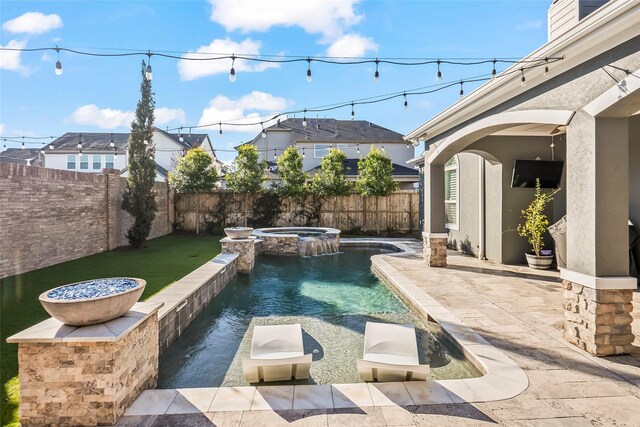 view of swimming pool with a pool with connected hot tub, a fenced backyard, and a patio