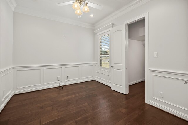 interior space featuring dark wood-type flooring, wainscoting, crown molding, and ceiling fan