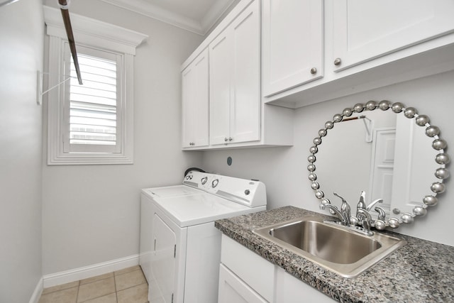 laundry room featuring light tile patterned floors, separate washer and dryer, a sink, ornamental molding, and cabinet space