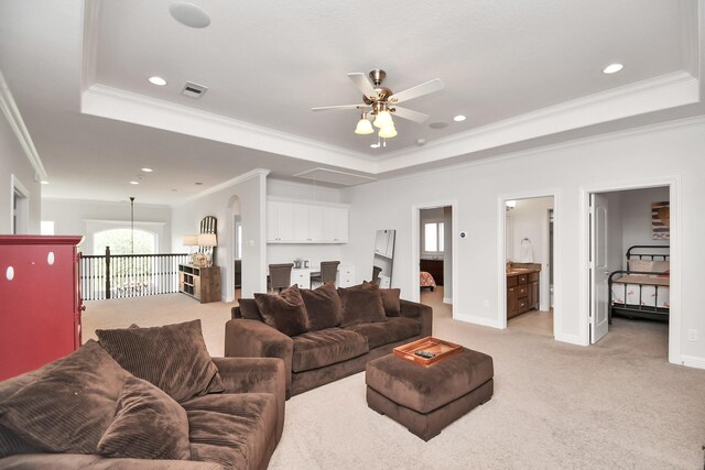 living area featuring a tray ceiling, visible vents, plenty of natural light, and light carpet