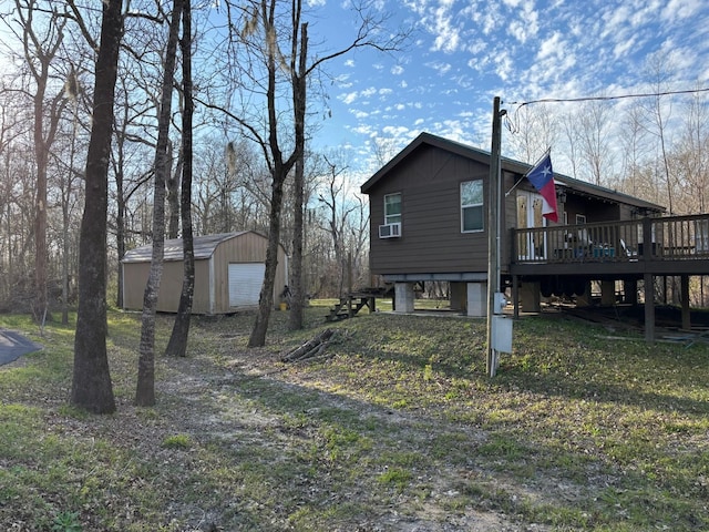 exterior space with a garage, an outdoor structure, a wooden deck, and cooling unit