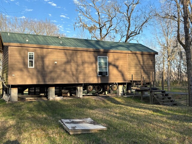 view of property exterior featuring metal roof and a yard