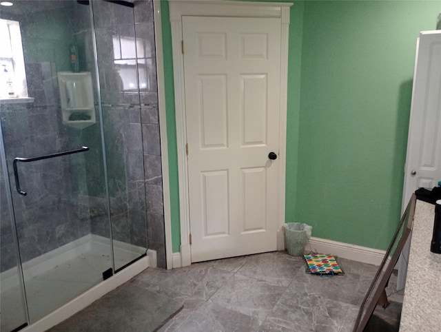 bathroom with a stall shower and baseboards